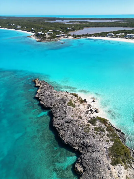 aerial view of rocky island and small beach with larger island in distance