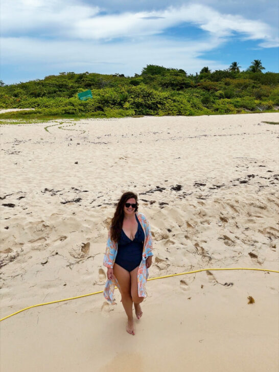 woman standing in blue swimming suit with kimono and sunglasses on beach Puerto Rico packing list