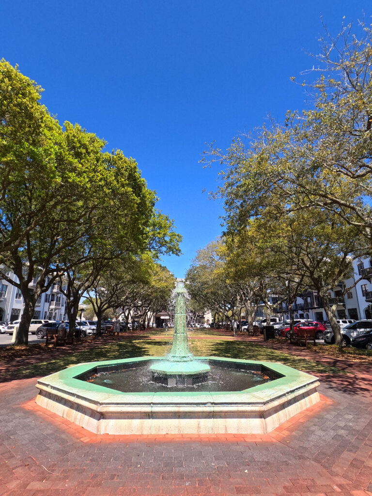 water fountain in center of green trees surrounding it