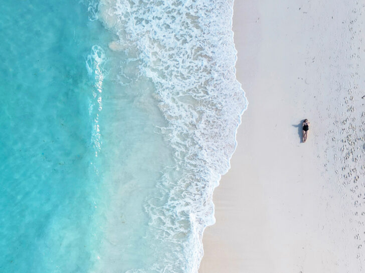 enjoying the luxurious beach while laying on the sand and the blue water and wave splashing