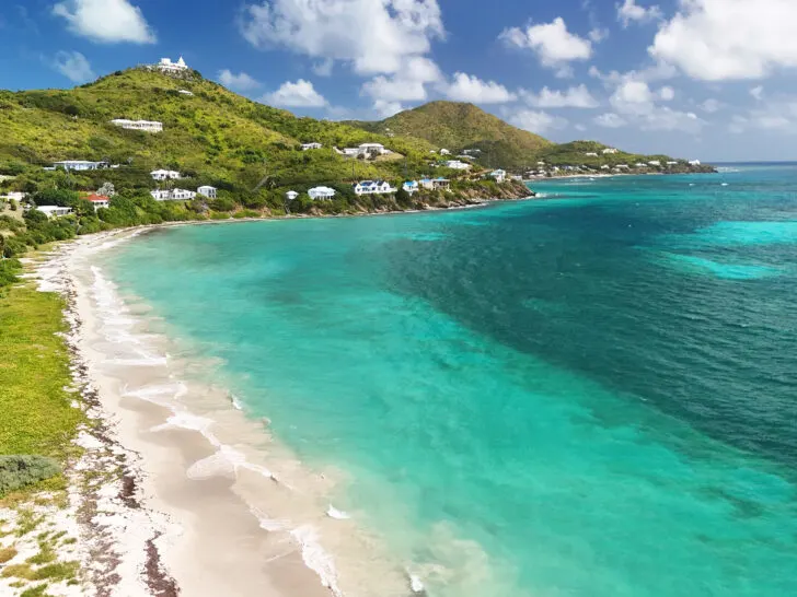 best beaches in St Croix view of teal water with white sand beach and rolling hills