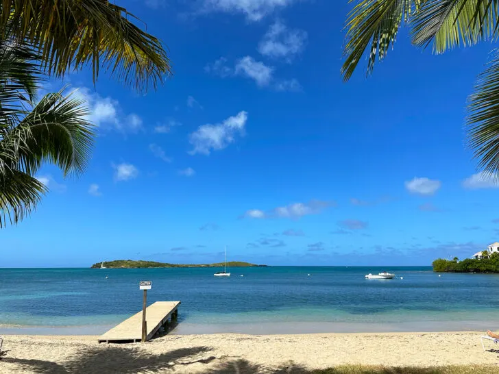 best beaches st Croix USVI view of palm trees pier and blue water white beach