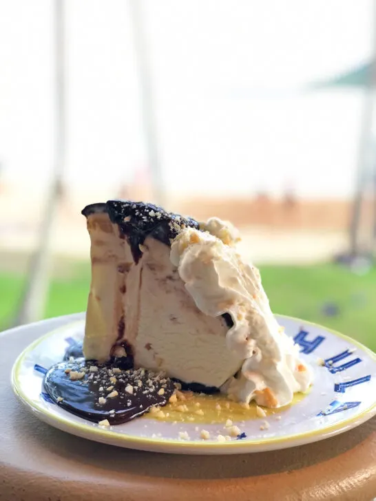 view of large piece of ice cream pie with chocolate and whipped cream