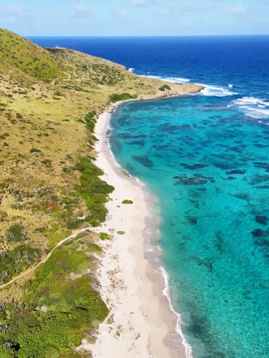 beautiful view of USVI with green hill white sand and bright blue water