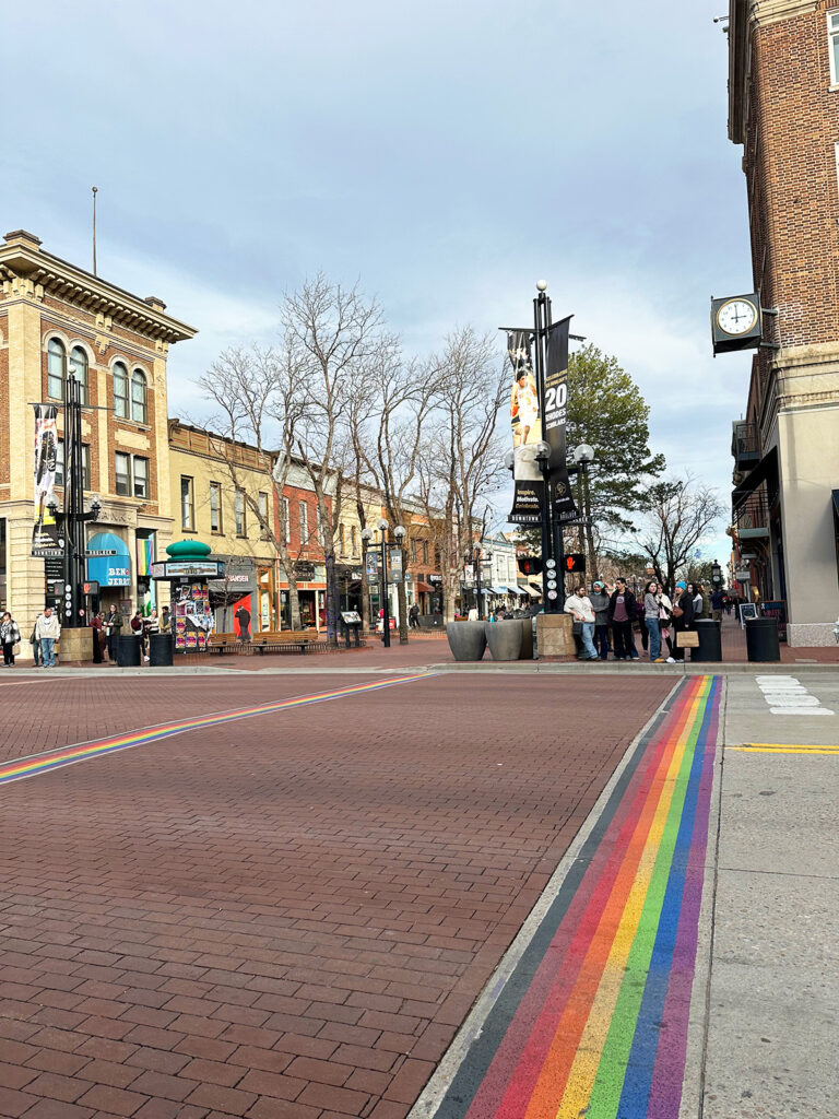 view of street in boulder colorado with rainbow stripe and buildings on a colorado road trip