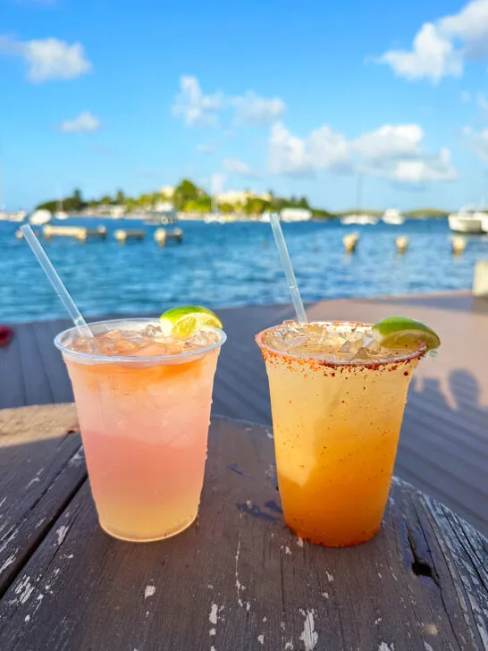 view of two cocktails on a bar top with ocean in distance