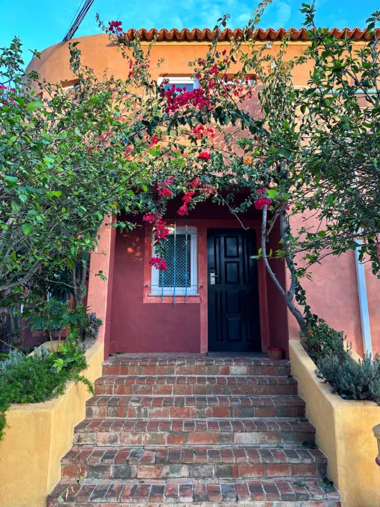 beautiful brick steps with hotel door and pink flowers surrounding