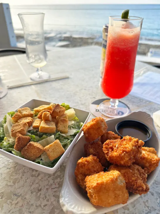 best places to eat st croix USVI view of fruity drink, crusted fish and salad with ocean in distance