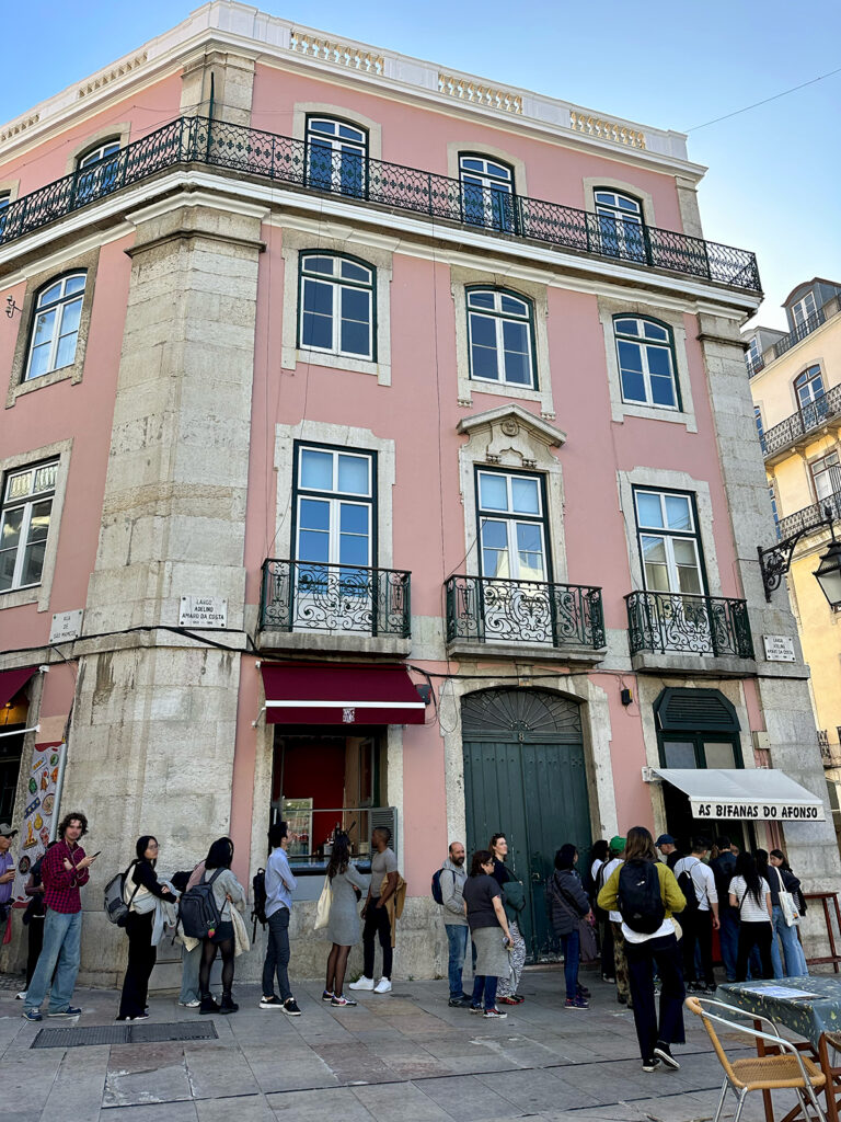 view of pink building with people standing outside of it