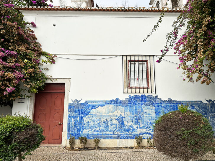 building with ornate blue tile with greenery and purple flowers