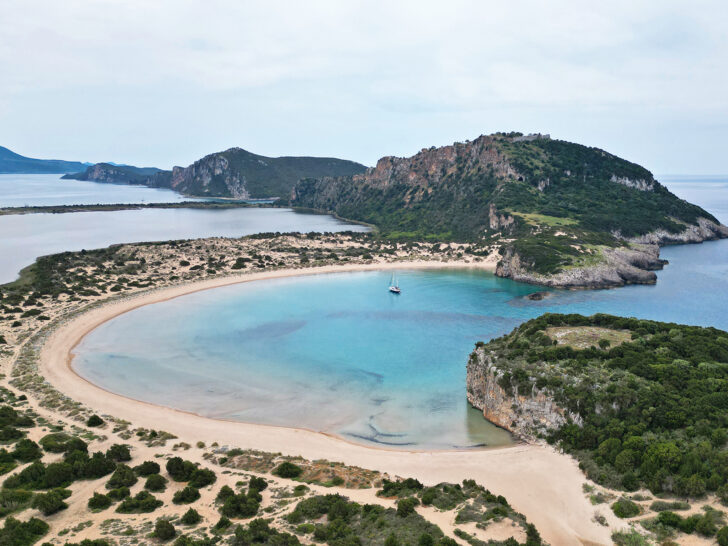 Greece mainland itinerary 2 weeks drone photo of a crescent shaped beach with cliffs surrounding and blue water