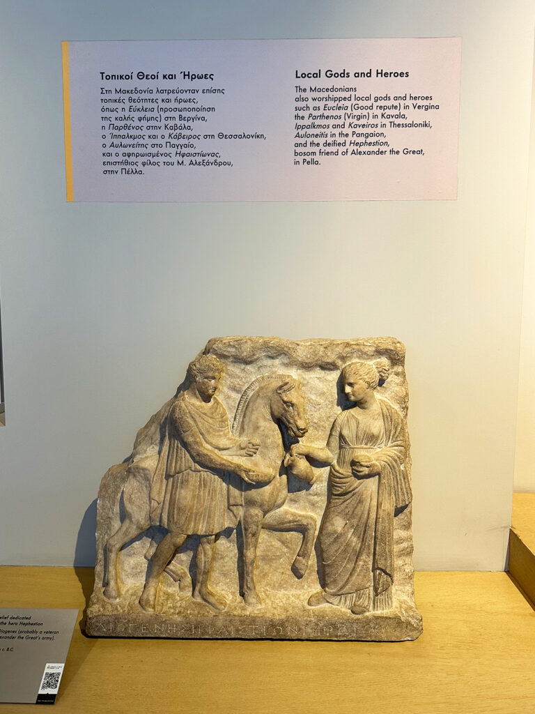 view of museum artifact with description of local gods and heroes in English and greek