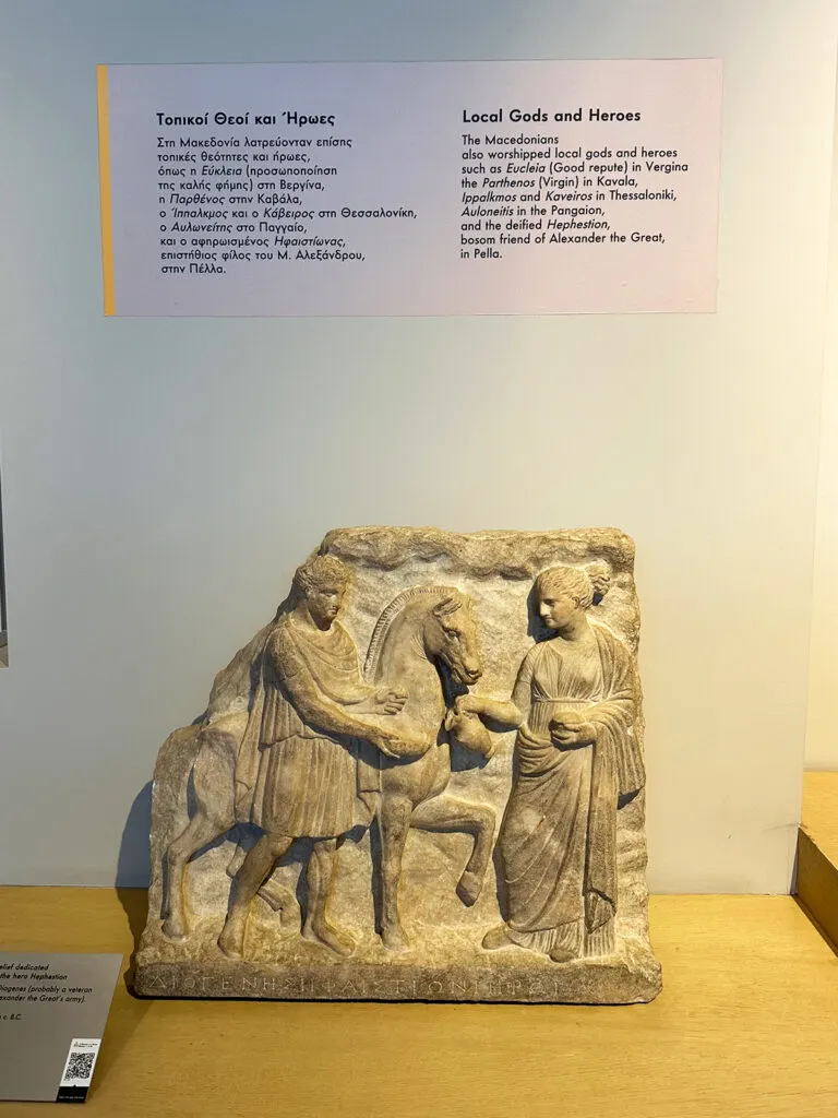 view of museum artifact with description of local gods and heroes in English and greek