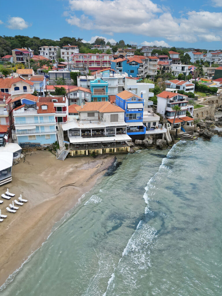 view of brightly colored buildings near water on hillside in Greece