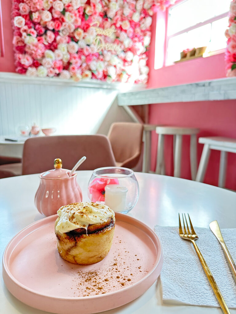 view of cinnamon roll in a very pink cafe