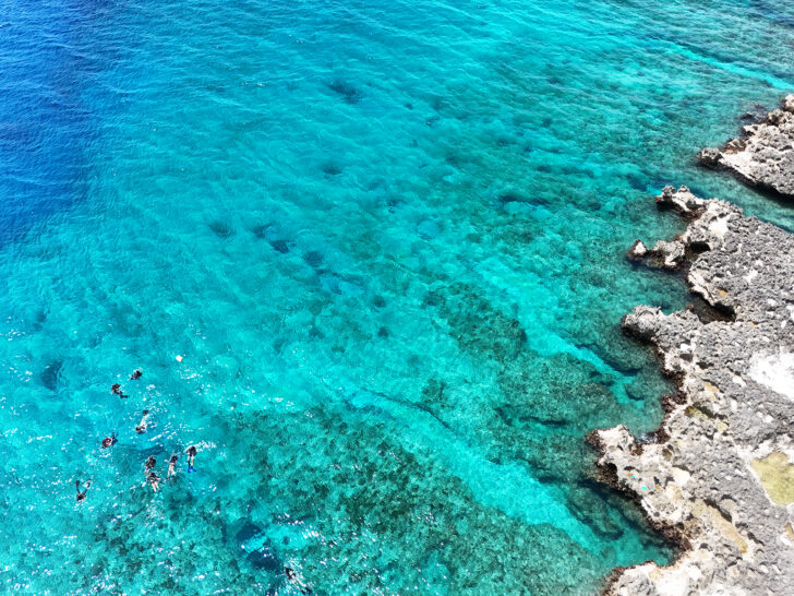 bright teal water with snorkelers in water near Cayman Islands