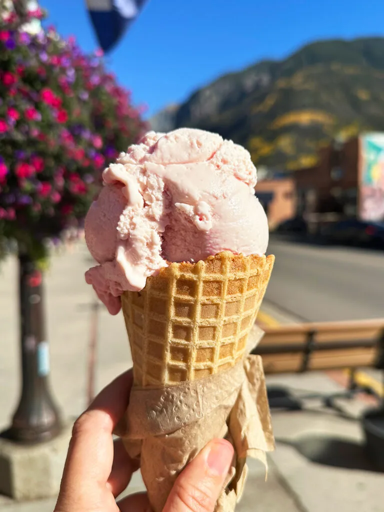 hand holding pink ice cream cone