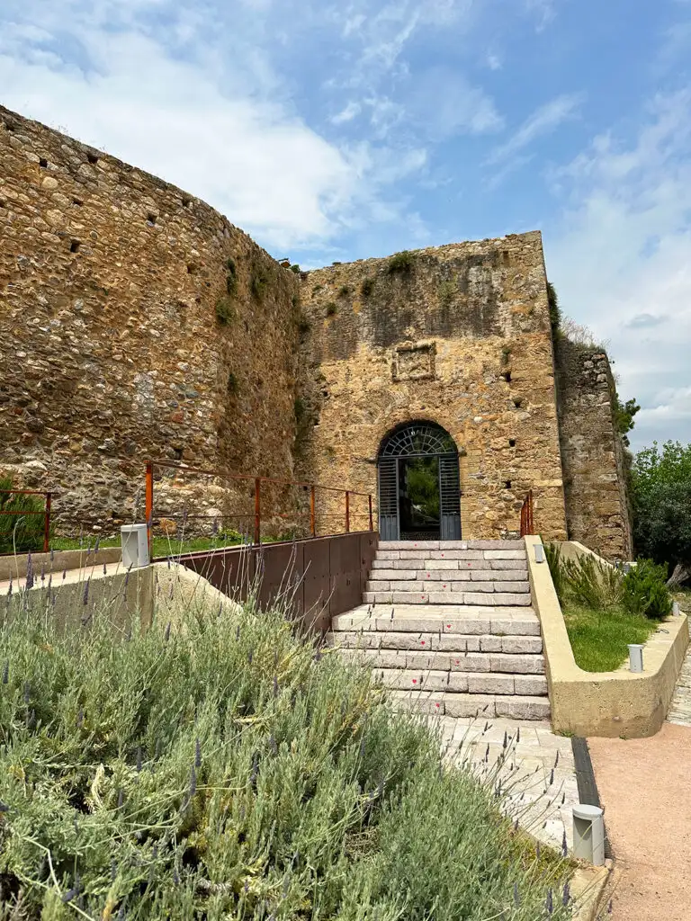view of steps leading to old walls of castle with blue sky
