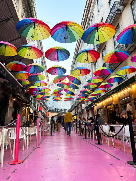 pink street with umbrellas and tables lining it Lisbon itinerary 3 days