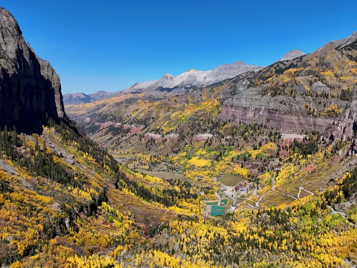 Telluride in the fall with view of yellow orange and green trees with colorful mountains