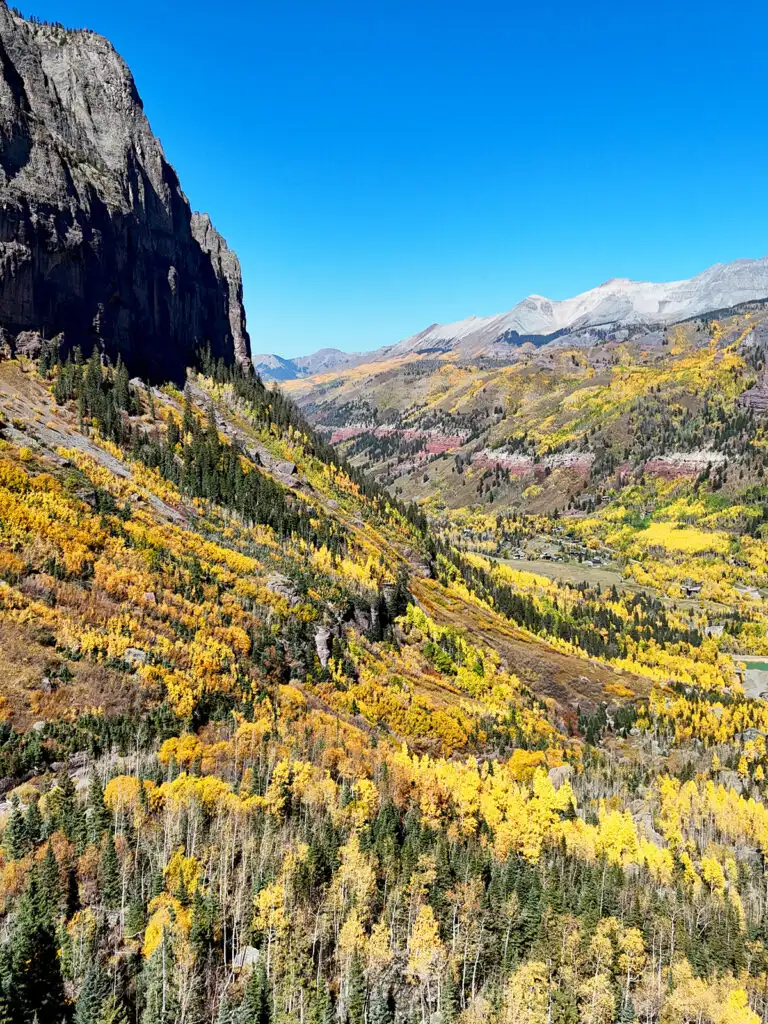 where to see fall foliage colorado view of green and orange trees on San Juan mountains