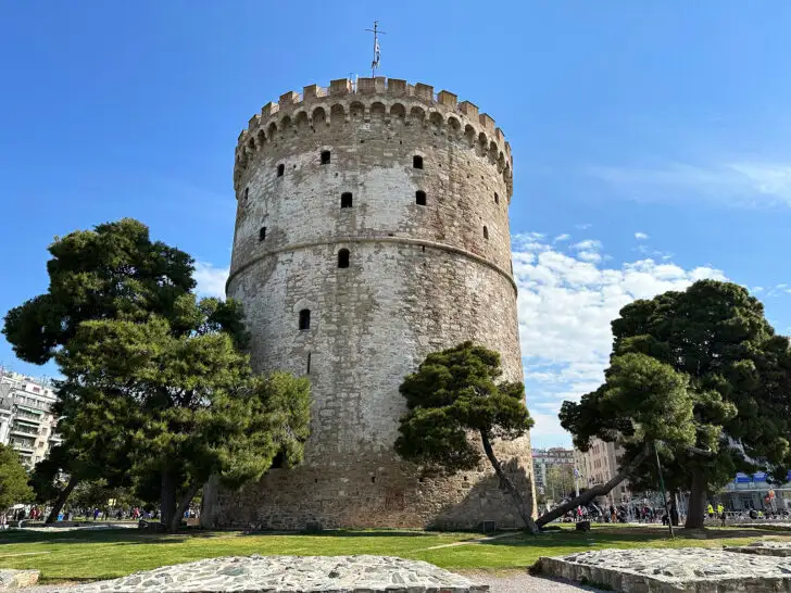 best Greece itinerary view of large white tower in northern Greece with trees and city behind