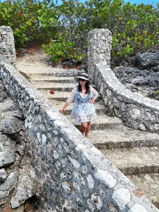 woman standing on steps on stone wall
