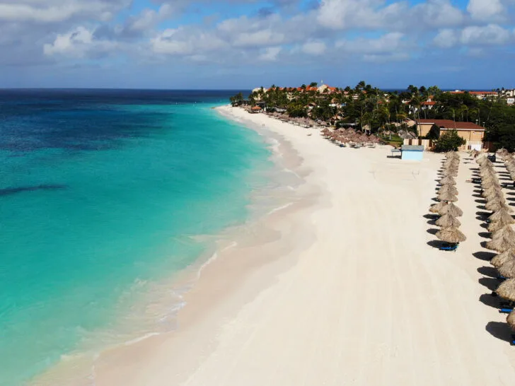 beautiful white sand beach drone photos with palapas and teal water