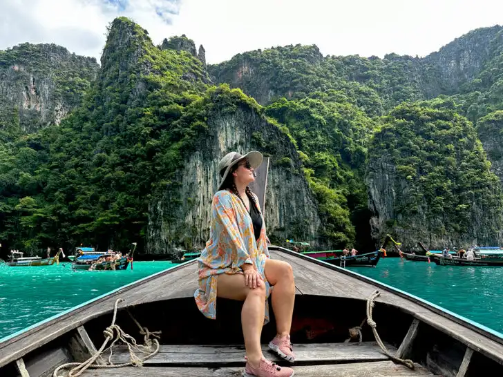 10 days Thailand itinerary with woman sitting on boat with karsts in distance