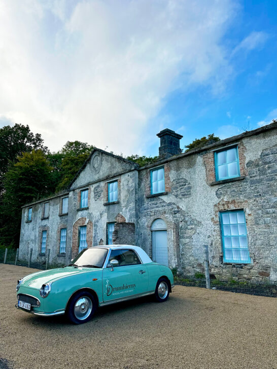 classic car parked in front of old building with blue sky