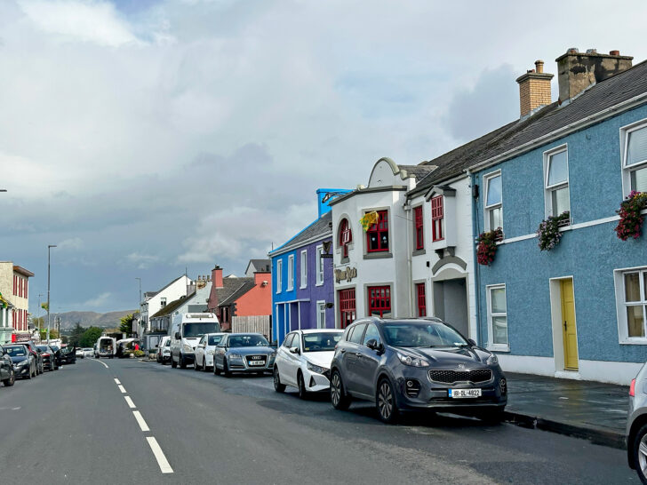 cars on street in small town with colorful buildings