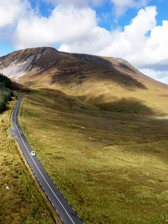 road through national park in Ireland with blue sky and brown terrain